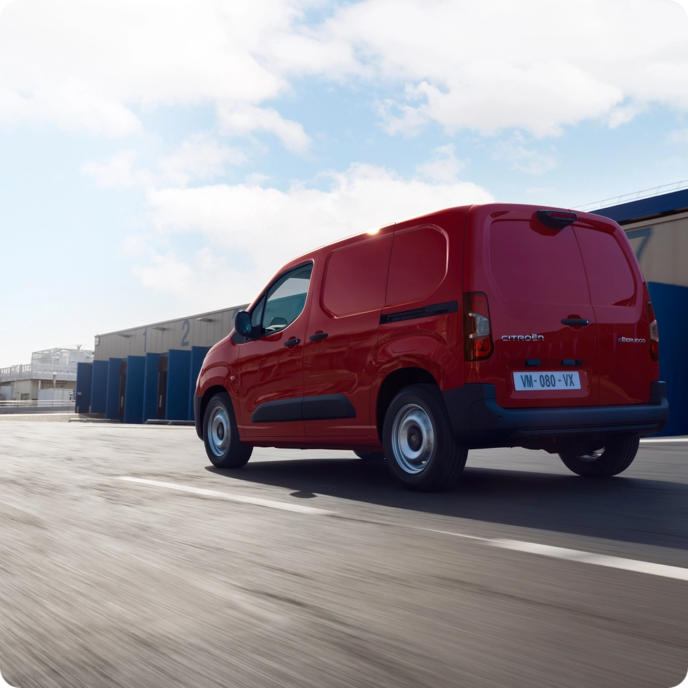Achteraanzicht in driekwart perspectief van een Citroën ë‑Berlingo Van rijdend op de weg, met een efficiënt elektrisch design, bewegingsvrijheid en een zelfverzekerde uitstraling.