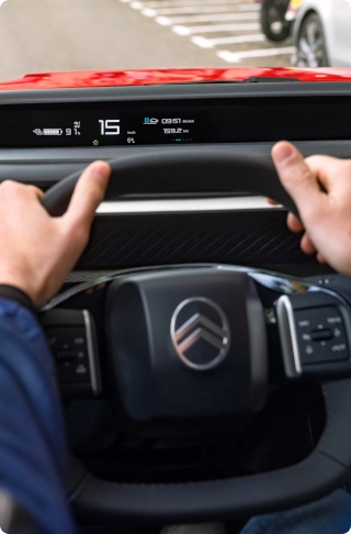Interieurzicht van de cockpit van de Citroën ë-C3 Van, met nadruk op het multifunctionele stuurwiel en de op de bestuurder gerichte bedieningselementen.
