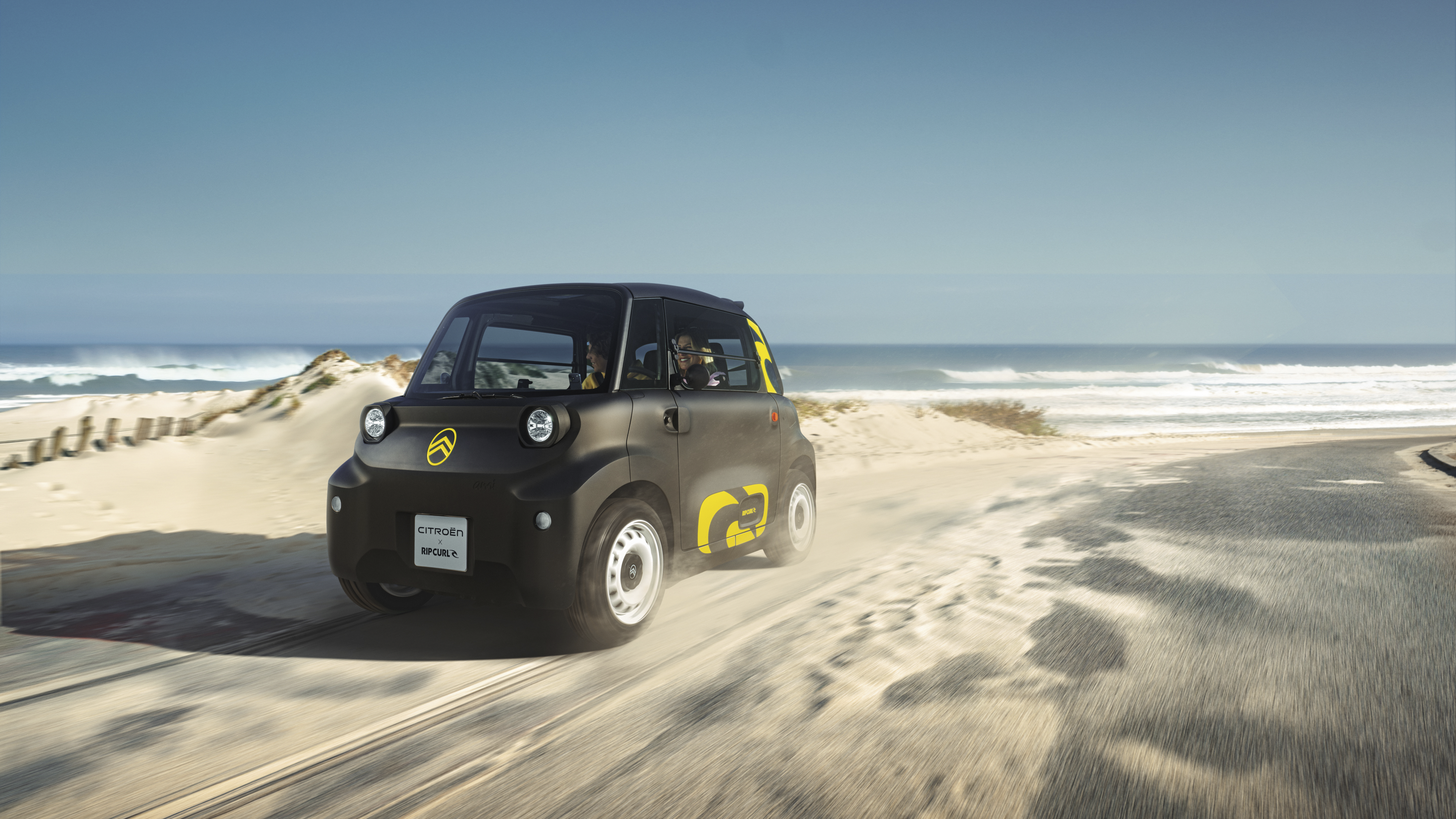 Driekwart vooraanzicht van de Citroën Ami x Rip Curl in actie, elektrische auto zonder autorijbewijs, als illustratie van vrijheid in de stad.
