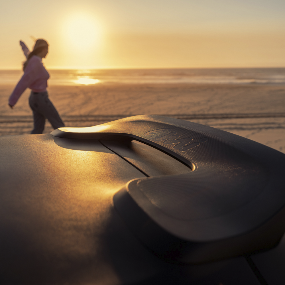 Close‑up van de dakgreep van de Citroën Ami x Rip Curl bij zonsondergang, met strandachtige lifestyle‑uitstraling.