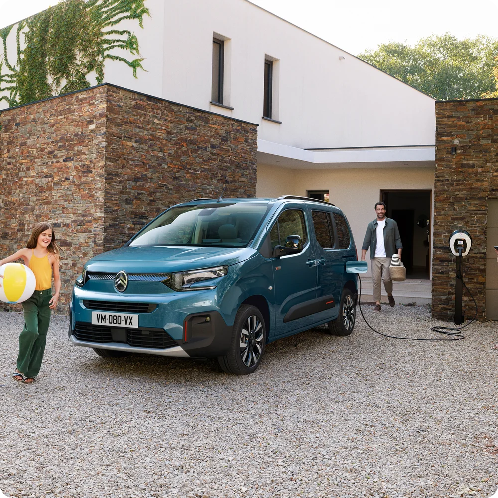 Zijaanzicht van de Kiama Blue ë-Berlingo tijdens het opladen: een toonbeeld van veiligheid, efficiëntie en technologie, en een voorbeeld van zelfverzekerd dagelijks gebruik van openbare oplaadpunten