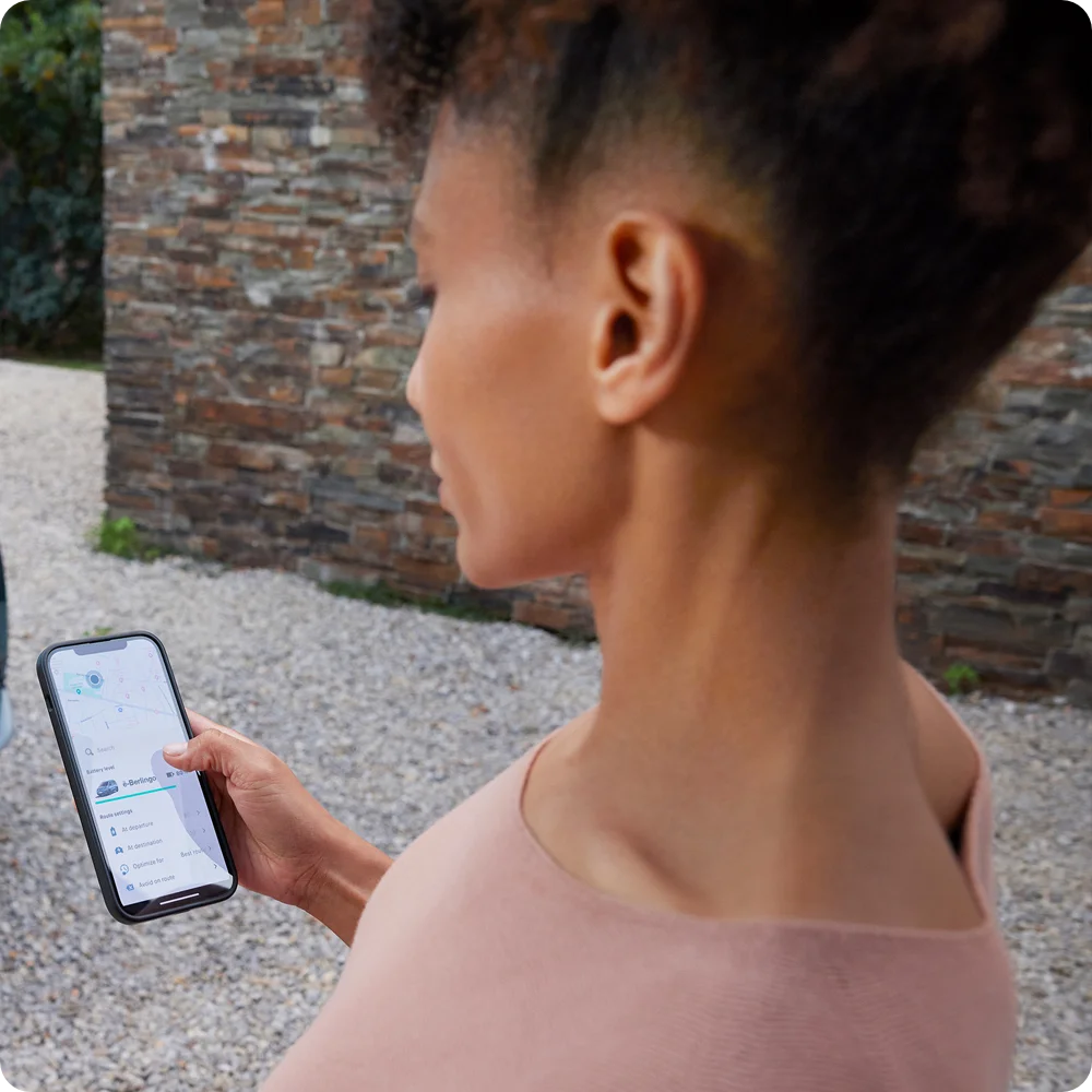 Detailweergave op smartphone met oplaadgegevens van de ë‑Berlingo, met informatie over connectiviteit, veiligheid, efficiëntie en een vlottere planning van lange ritten