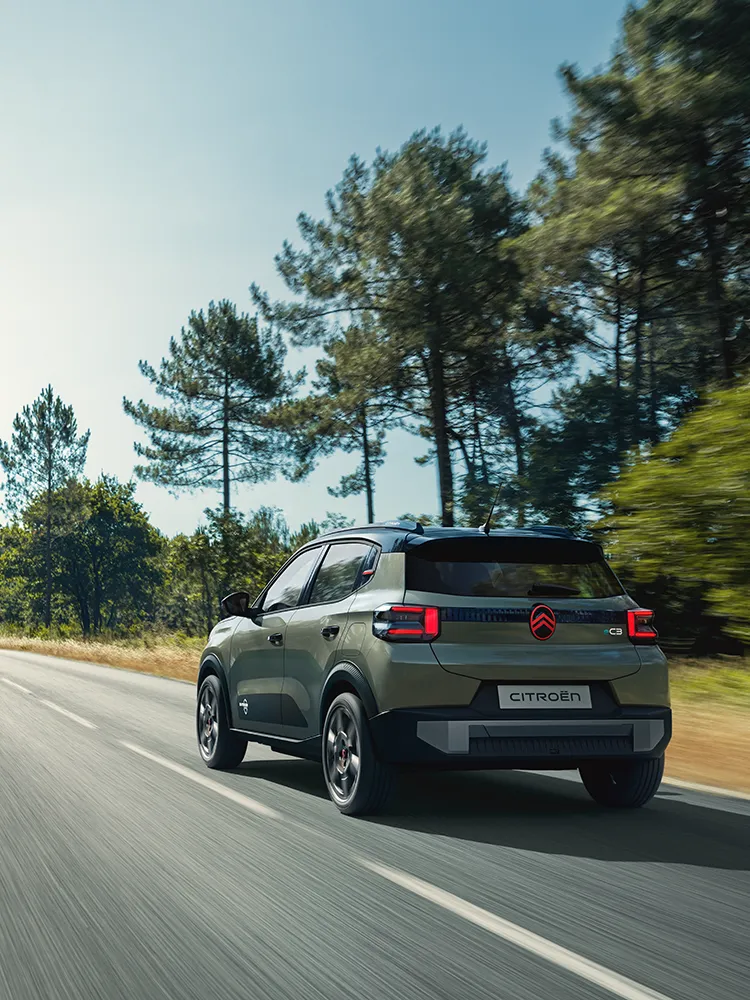 Rear three-quarter view Citroën ëC3 Outdoor with LED taillights shows Advanced Comfort compact SUV on open road