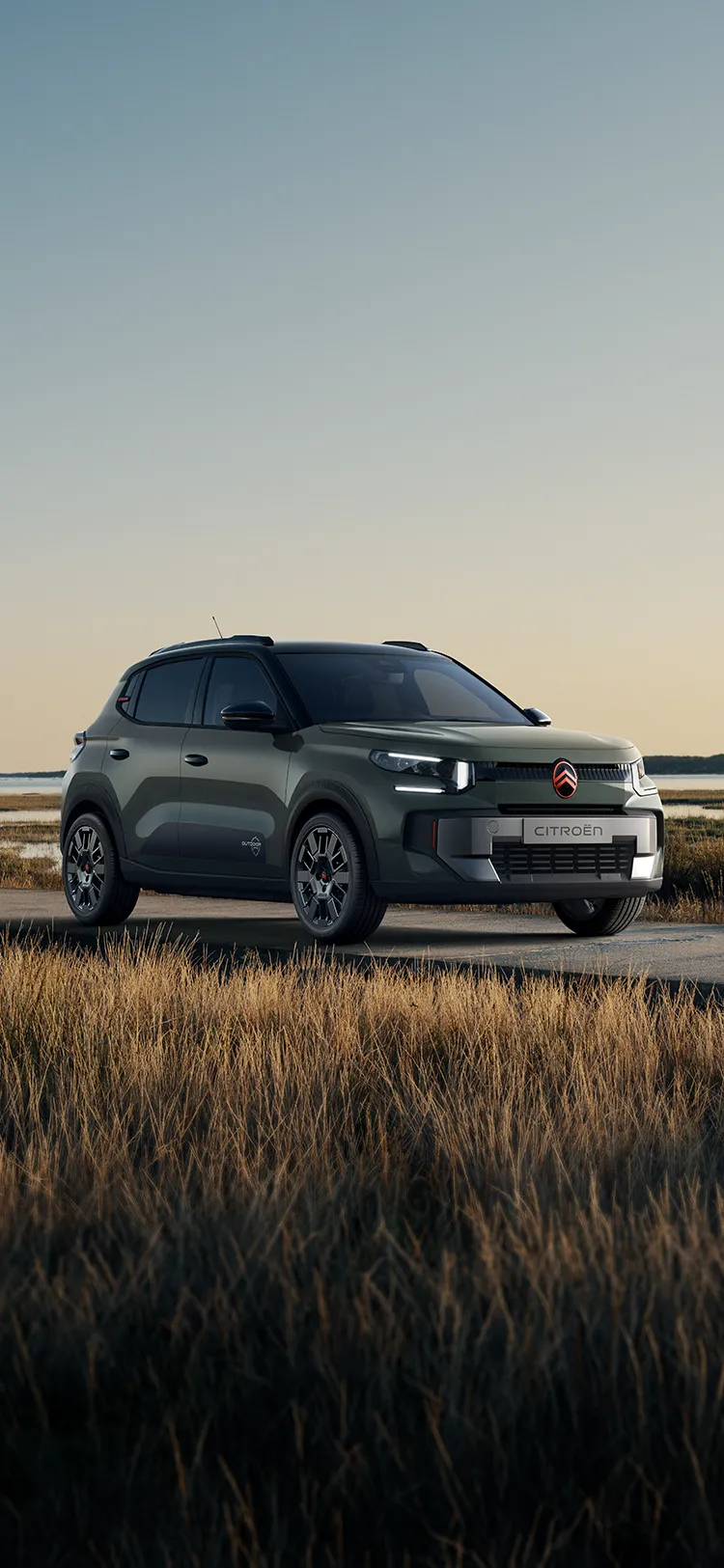 Front three-quarter view Citroën ëC3 Outdoor with LED signature shows Advanced Comfort SUV beside coastal wetlands