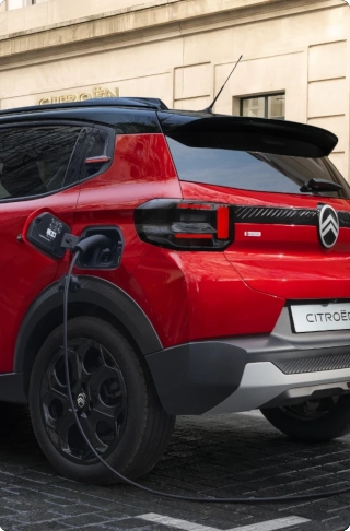 Driekwart achteraanzicht van de Citroën ë‑C3 elektrische SUV met eenvoudig toegankelijke laadpoort voor efficiënte en betaalbare dagelijkse stedelijke mobiliteit.