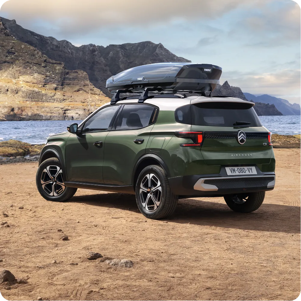 Buitenaanzicht van de Citroën ë‑C3 Aircross elektrische SUV met dakdragers en dakkoffer voor veelzijdige, ruime en betaalbare reismogelijkheden.