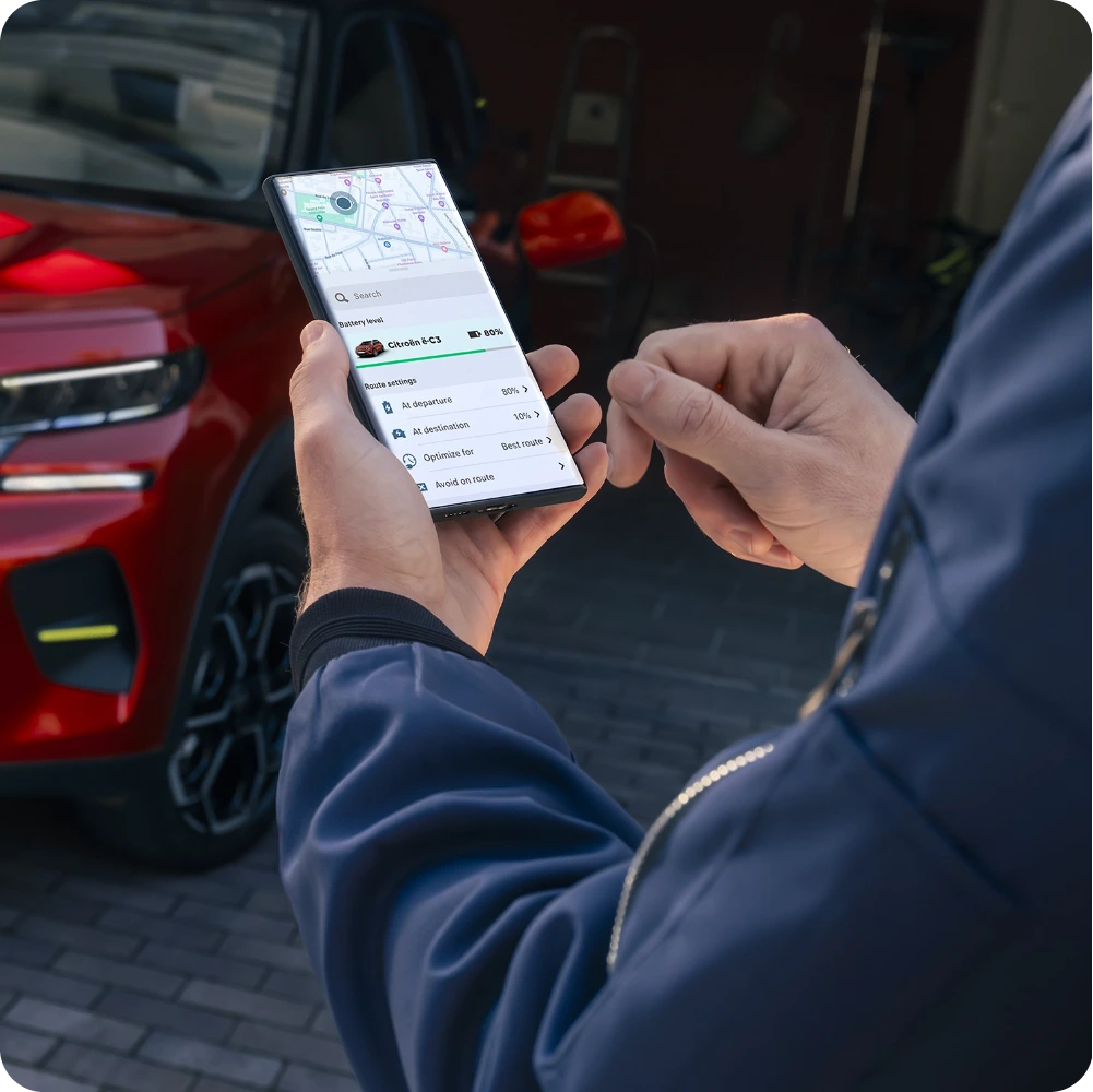 Persoon die een smartphone gebruikt om Citroën connected services te openen voor voertuigbeheer en functies op afstand.