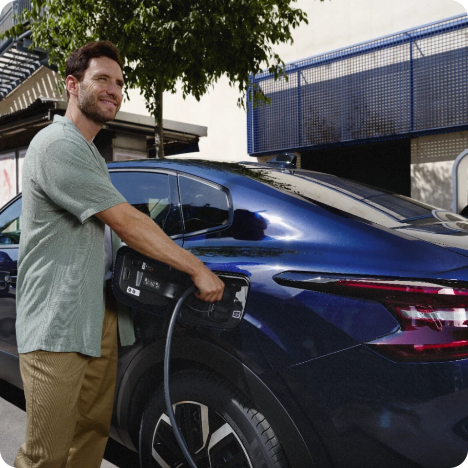 Persoon die de Citroën ë‑C4 X oplaadt aan een thuislader, ter illustratie van toegankelijke elektrische‑mobiliteitsoplossingen.