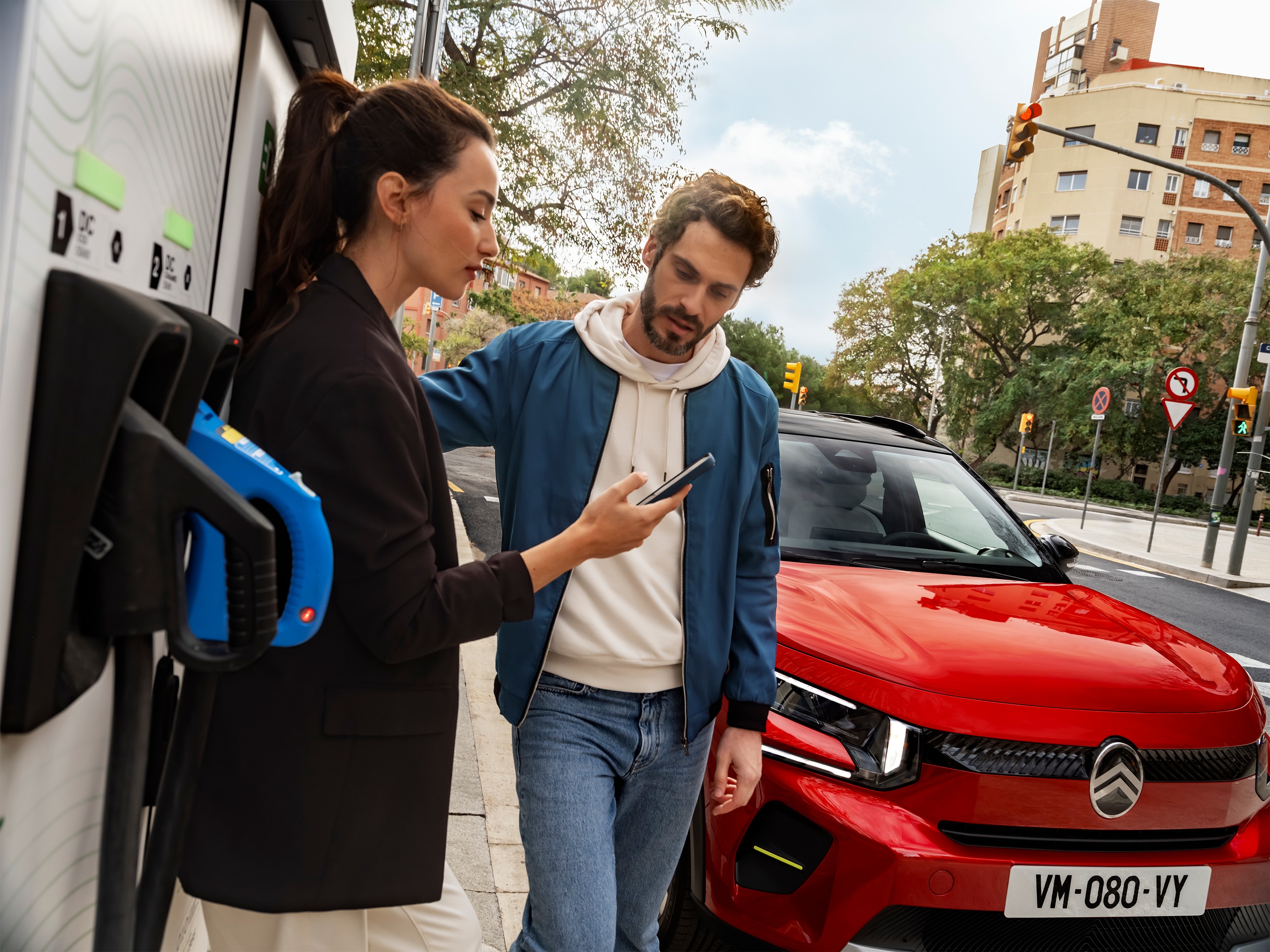 Opladen op straat van de Citroën C3 SUV terwijl mensen een snellaadsessie voorbereiden voor efficiënte en betaalbare stedelijke mobiliteit.