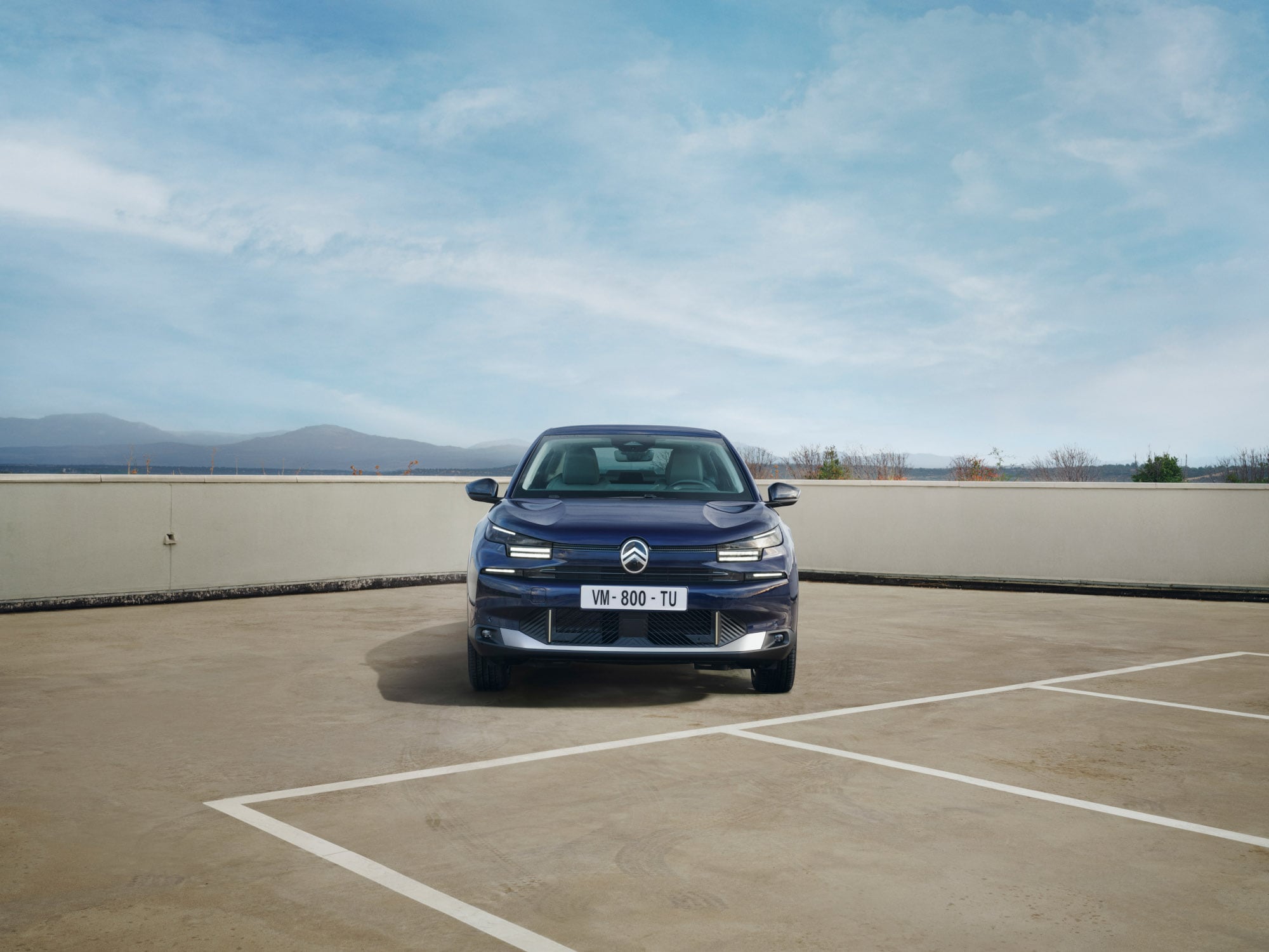 Vooraanzicht van de Citroën C4 X op een dakterrein met krachtige fastback‑houding voor zelfverzekerde en betaalbare mobiliteit.