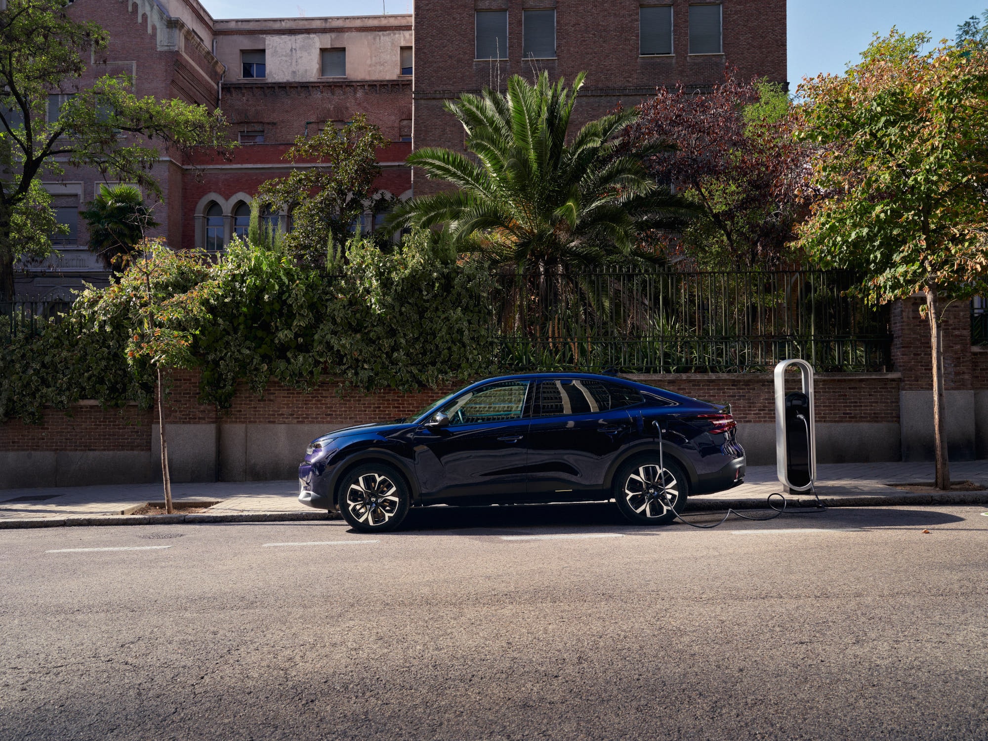 Zijaanzicht van de elektrische fastback Citroën C4 X tijdens straatladen, met nadruk op gemakkelijke en betaalbare stedelijke mobiliteit.