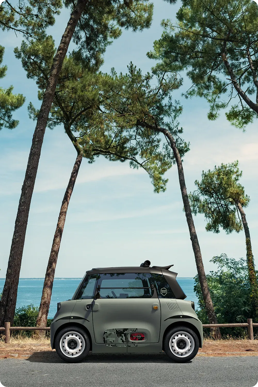 Zijaanzicht van de Citroën Ami Outdoor: compact, elektrisch en toegankelijk, met een innovatief design voor stedelijke mobiliteit aan zee.